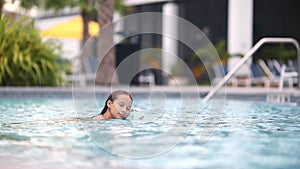 Teen girl swimming in pool