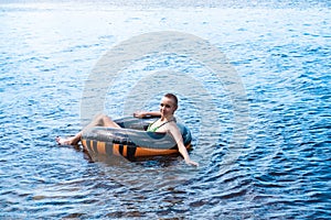 Teen girl swimming using a swim tube