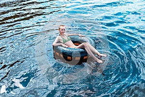 Teen girl swimming using a swim tube