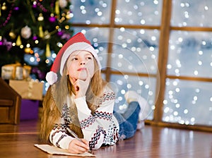 Teen girl thinking what to write in a letter to Santa Claus