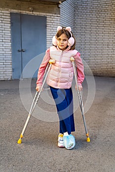 teen girl to walk on crutches. plaster on feet.