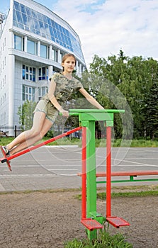 Teen girl trains on a swinging simulator outdoors