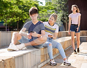 Teen girl trying to get attention of boy with phone