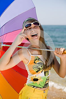 Teen girl with umbrella on seashore