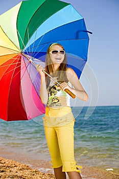 Teen girl with umbrella on seashore