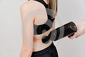 Teen girl uses a massage gun. medical-sports device