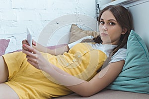teen girl using smartphone and lying photo