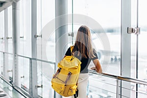 Teen girl waiting for international flight in airport departure terminal