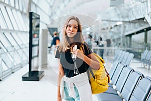 Teen girl waiting for international flight in airport departure terminal