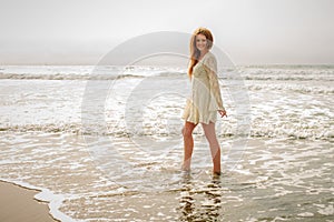 Teen girl walking in the ocean