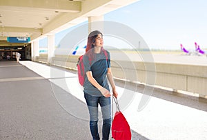 Teen girl walking through outdoor airport terminal