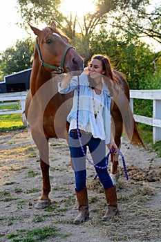 A teen girl walks with her horse