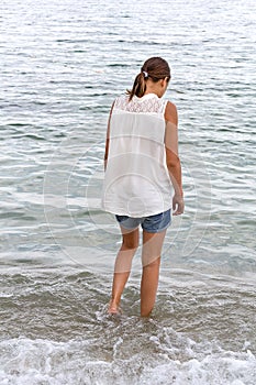 Teen girl walks into the sea