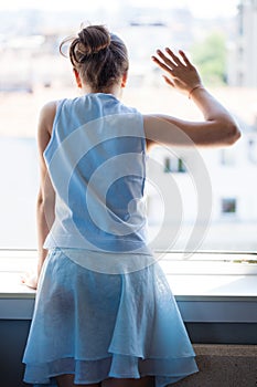 Teen girl wave with hand on window