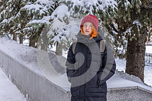 Teen girl wearing casual clothes walking on snow covered city street in winter. Young lady spending weekend in city. Urban