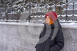 Teen girl wearing casual clothes walking on snow covered city street in winter. Young lady spending weekend in city. Urban