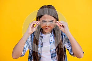 teen girl wearing checkered shirt. serious teen girl with long hair. teen girl in casual style. Young teen girl standing