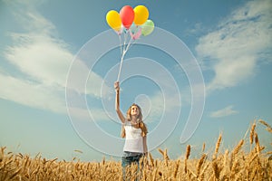 Teen girl at a wheat field with balloons