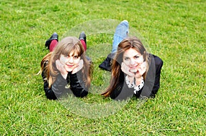 Teen girls laying on the green grass