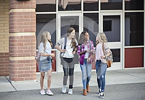 Teen girls leaving school talking and walking together