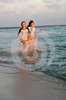 Teen girls running at beach