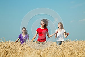 Teen girls running at the wheat field