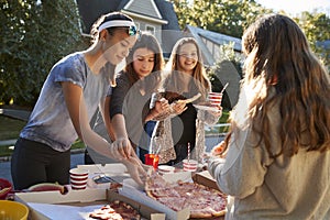 Teen girls sharing a pizza at a neighbourhood block party