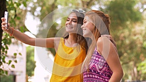 Teen girls taking selfie by smartphone in park