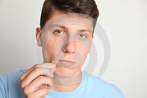Teen guy applying acne healing patch on background photo