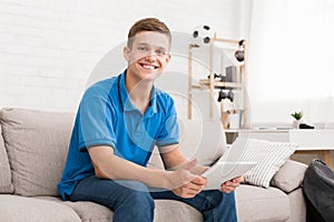 Teen guy using digital tablet at home