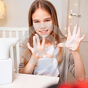 Teen hands disinfect with soap automatic dispenser