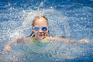 Teen happy girl playing in the swimming pool