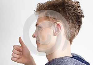 Teen with hearing aid showing thumb up