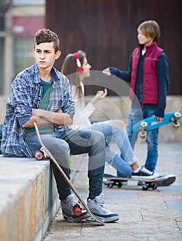 Teen and his friends after conflict outdoors