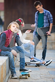 Teen and his friends after conflict outdoors