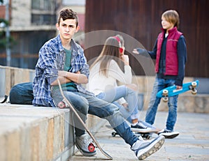 Teen and his friends after conflict outdoors