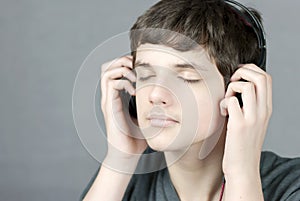 Teen Holds Headphones To Ears With Eyes Closed