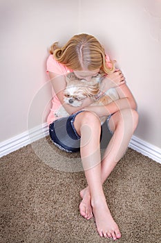 Teen hugging dog in corner