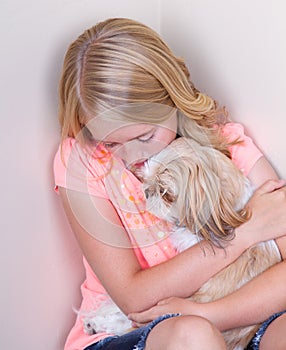 Teen hugging dog in corner