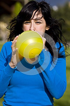 Teen inflating yellow balloon