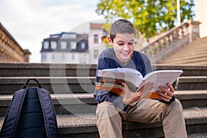Teen involved in reading on the steps outdoors