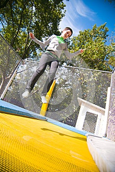 Teen jumping on trampoline