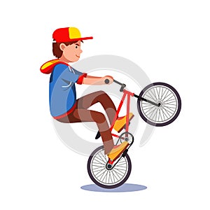 Teen kid doing wheelie stunt on a bmx bike