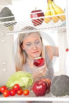 Teen looking at food in fridge