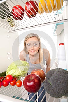 Teen looking at food in fridge