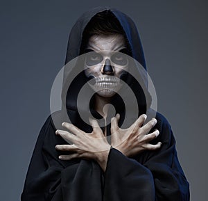 Teen with makeup closed skull hands