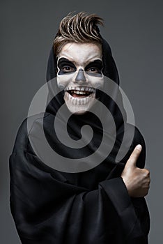 Teen with makeup skull showing thumbs up