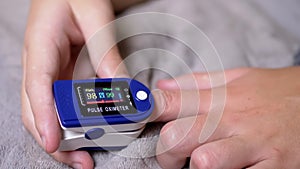 Teen Measures Pulse and Oxygen Saturation Using a Pulse Oximeter in Bedroom