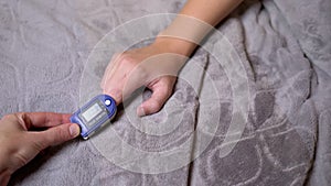 Teen Measures Pulse and Oxygen Saturation Using a Pulse Oximeter in Bedroom