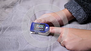 Teen Measures Pulse and Oxygen Saturation Using a Pulse Oximeter in Bedroom